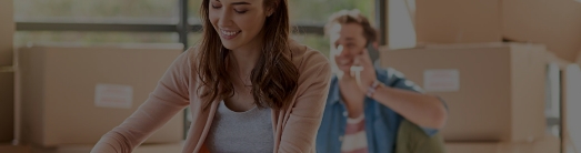 Imagem de um casal sorridente, com o foco na mulher a frente do homem na projeção